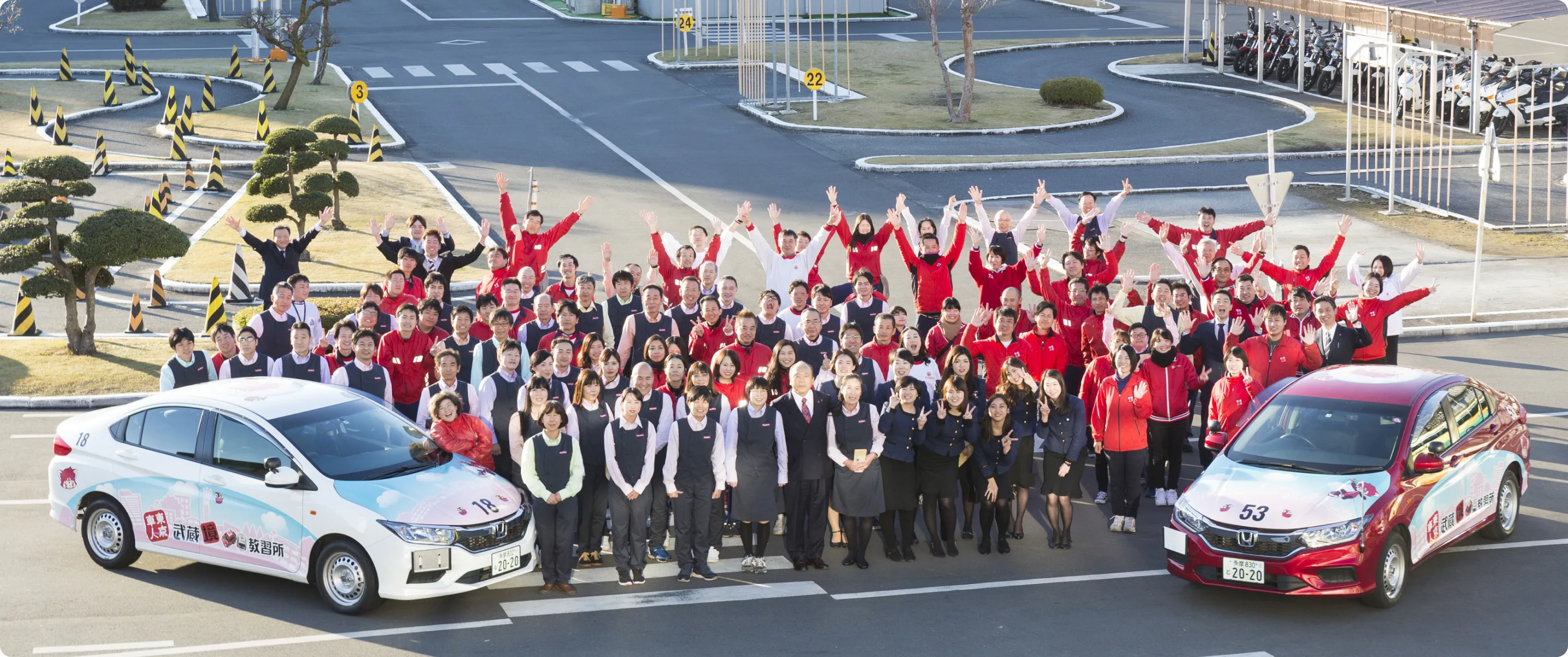 Musashisakai Driving School staff with training vehicles