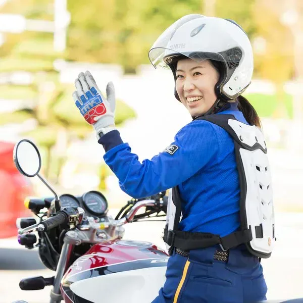 Student in riding gear beside a training motorcycle