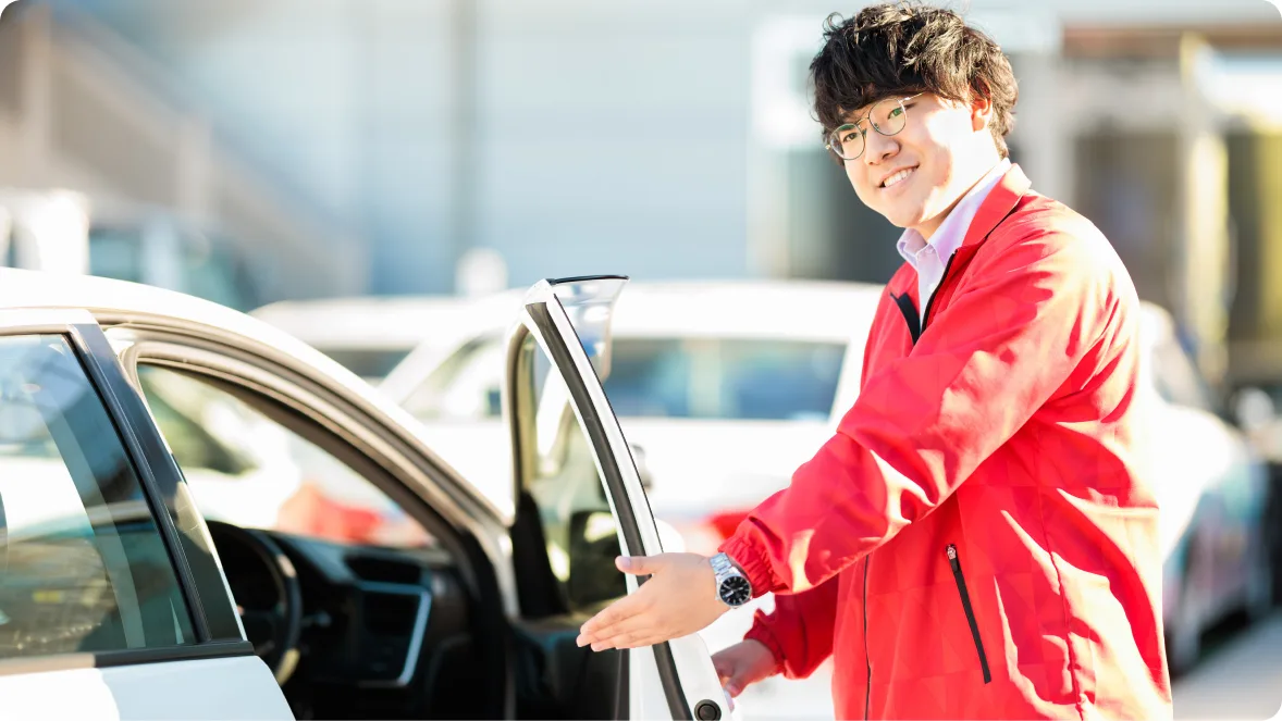 Instructor holding a car door open for a student