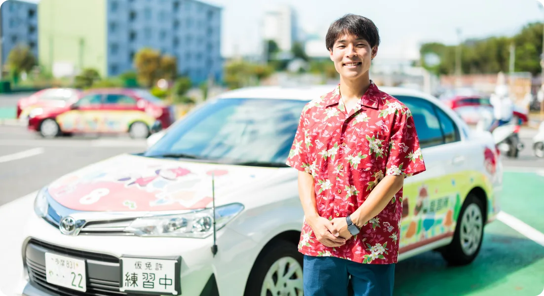 Student standing beside a training car