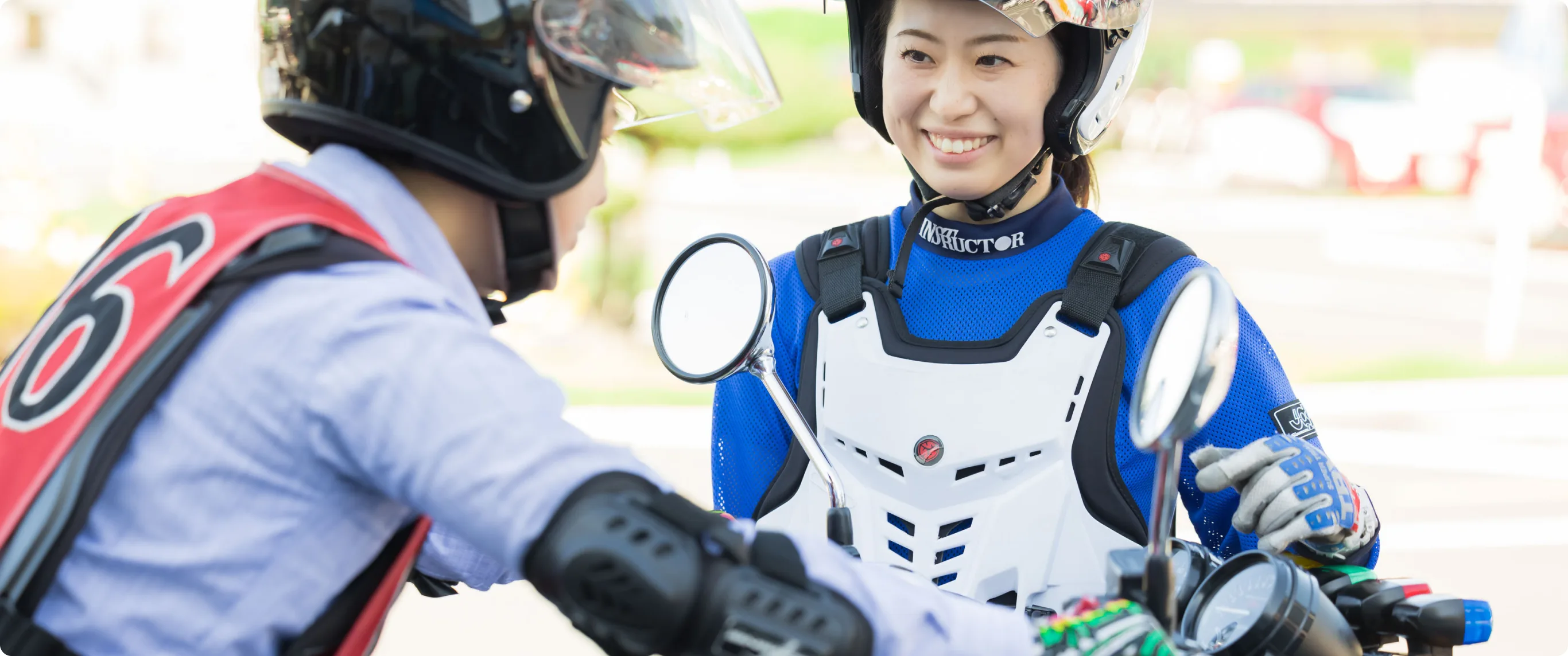 Rider in protective gear waving from a training motorcycle