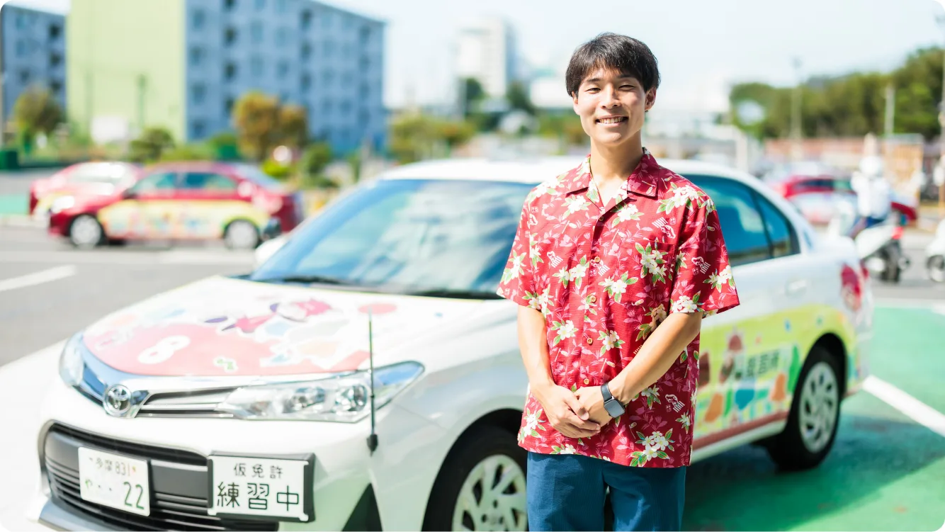 Student standing beside a training car