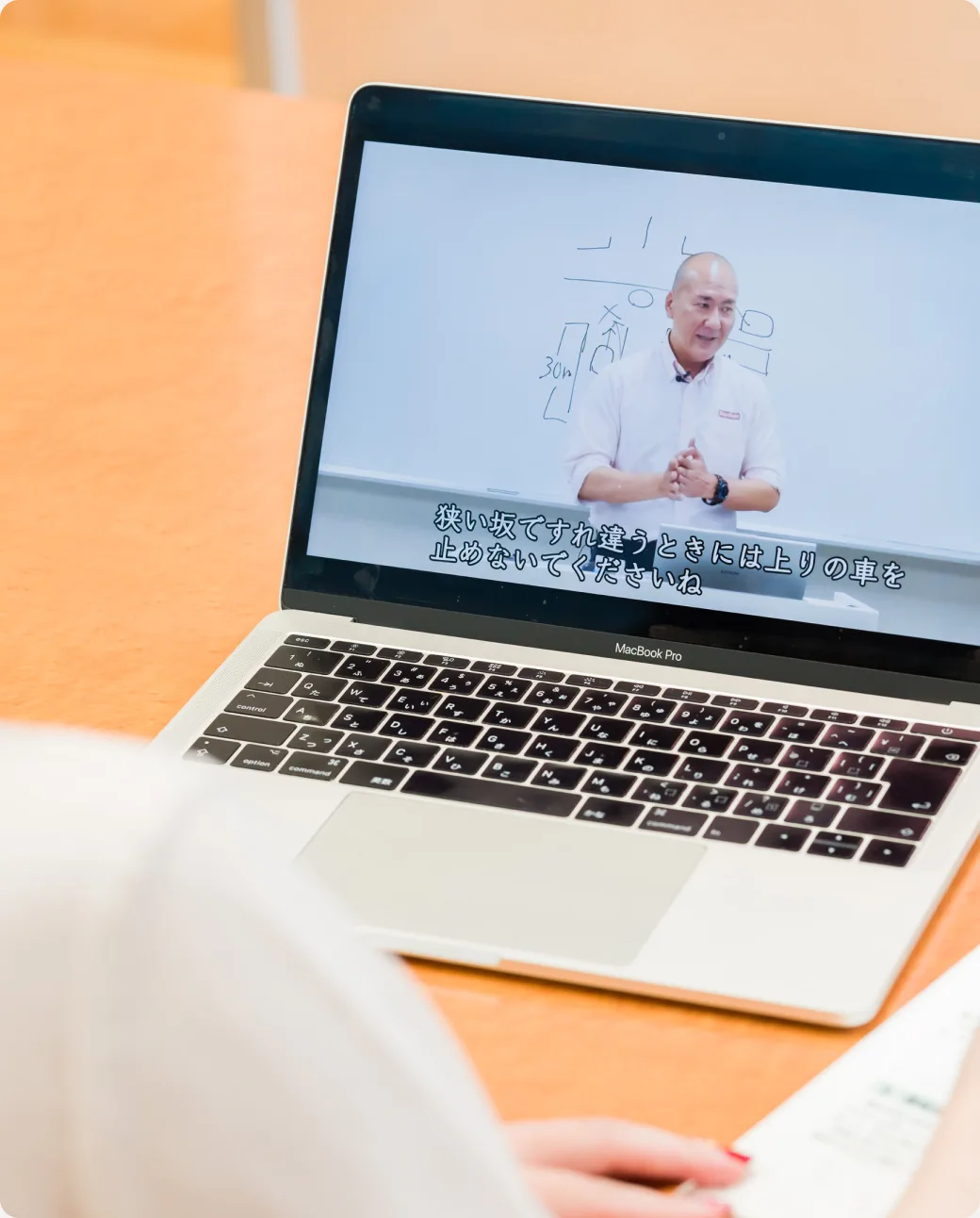 A student watching an online theory lesson on a laptop
